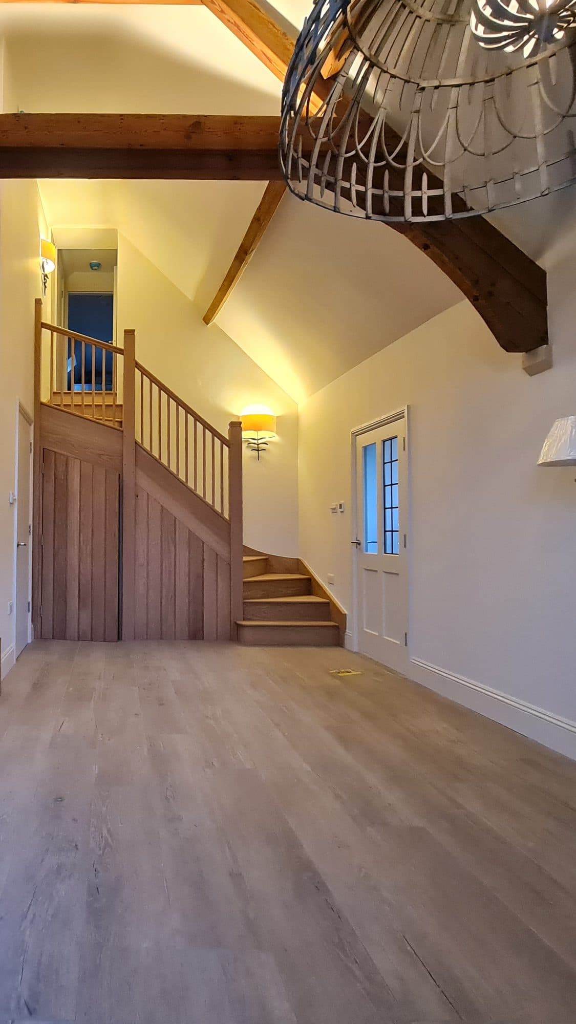 The end wall: oak staircase, landing and a glazed door