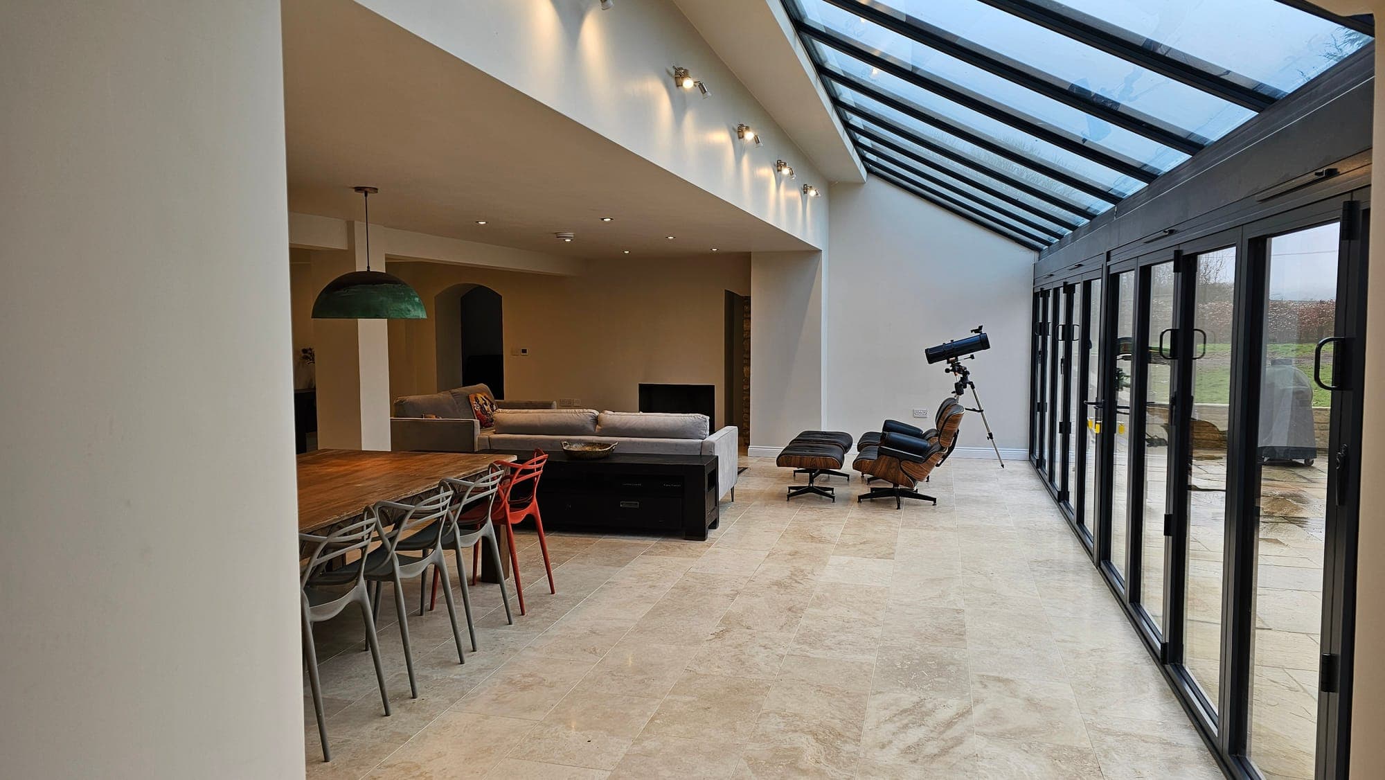 The living space beneath a long roof lantern, with sliding doors to the garden