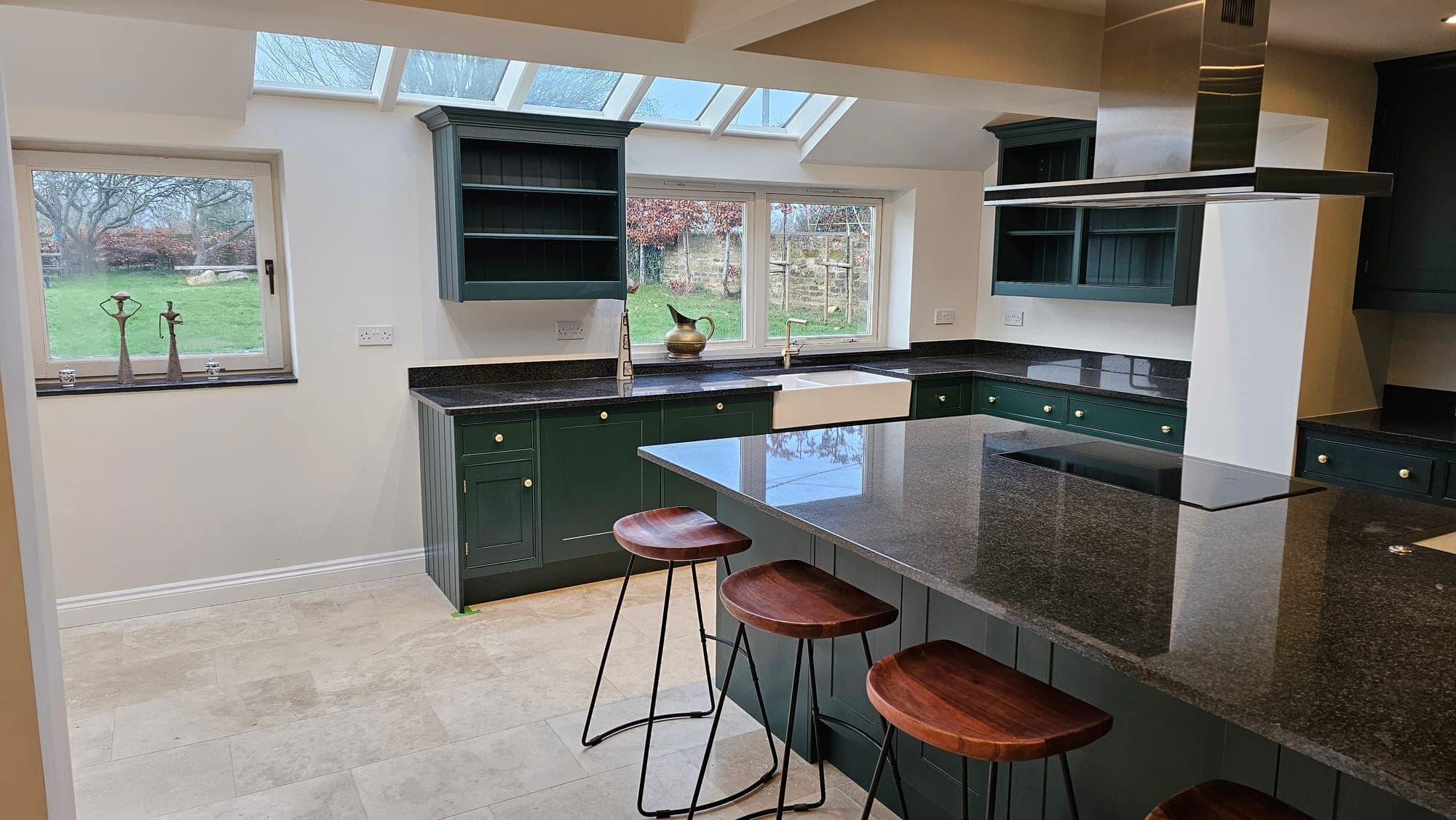 Kitchen island with a dark stone worktop under the roof lantern