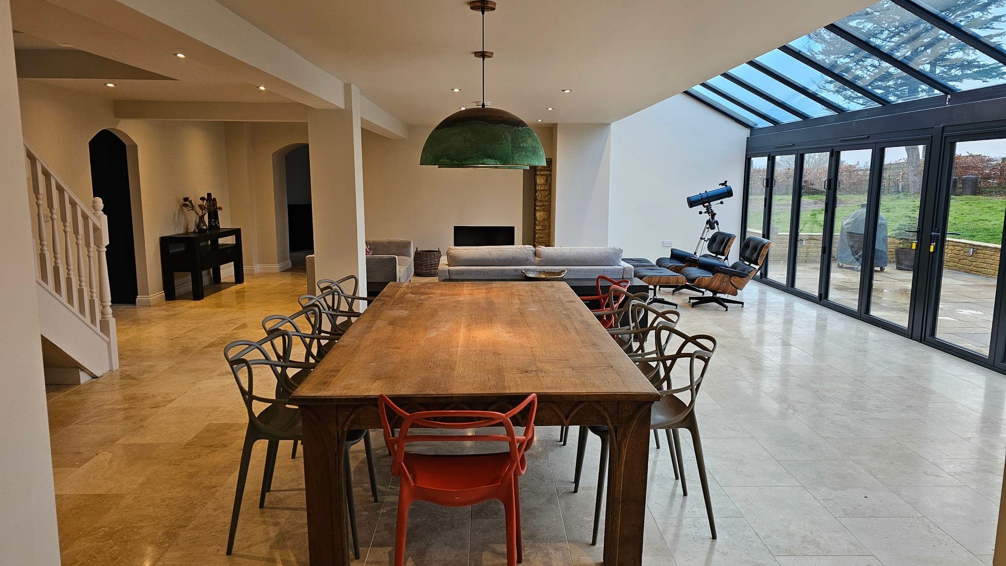 Dining table beneath the lantern, kitchen beyond