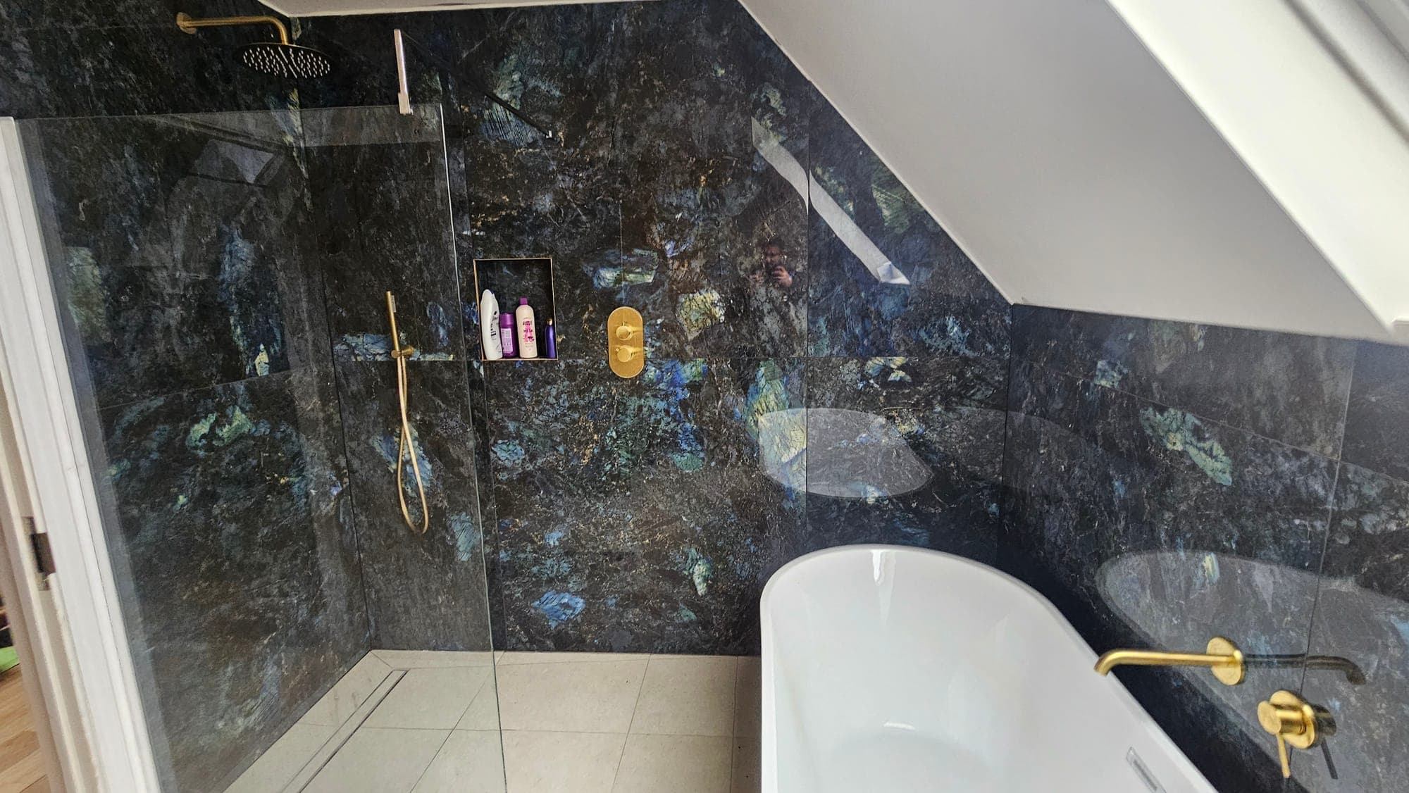 Bathroom in dark marble with a freestanding bath
