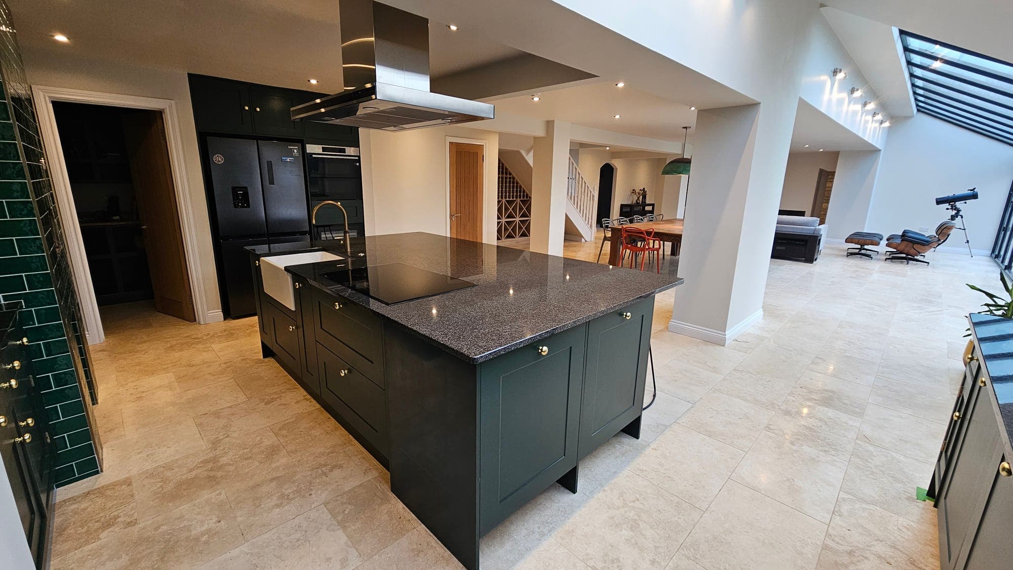 Kitchen with island, dark cabinetry and stone floor