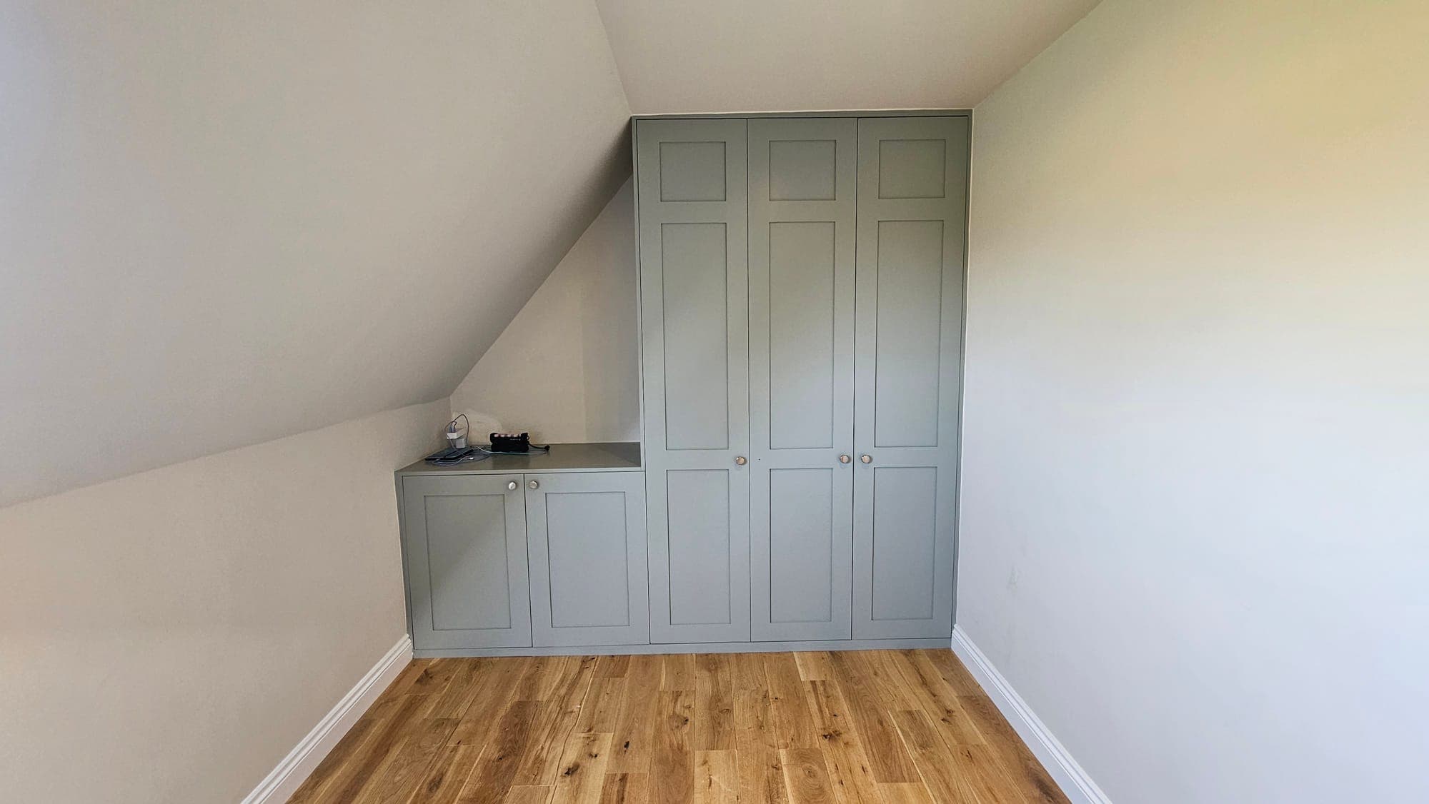 Fitted wardrobes in a bedroom under the eaves, painted