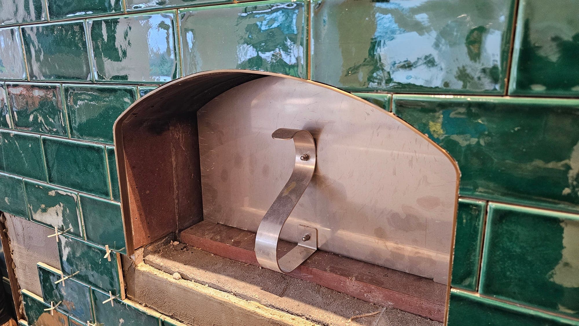 Copper hood fitted within the tiled range alcove